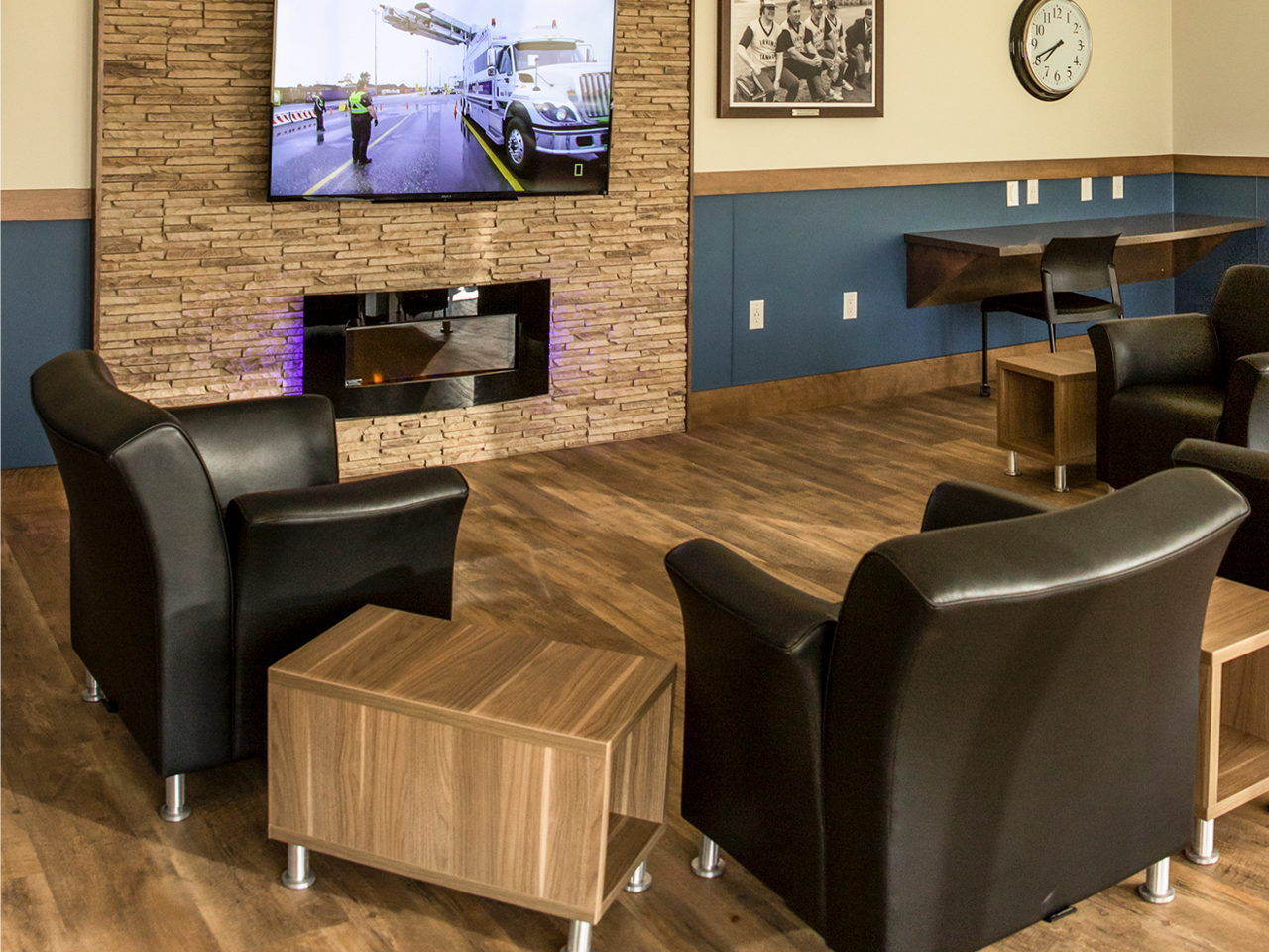 Irving 24 lounge with leather chairs, wooden tables, a wall-mounted TV, and a cozy decor, designed for relaxing in comfort