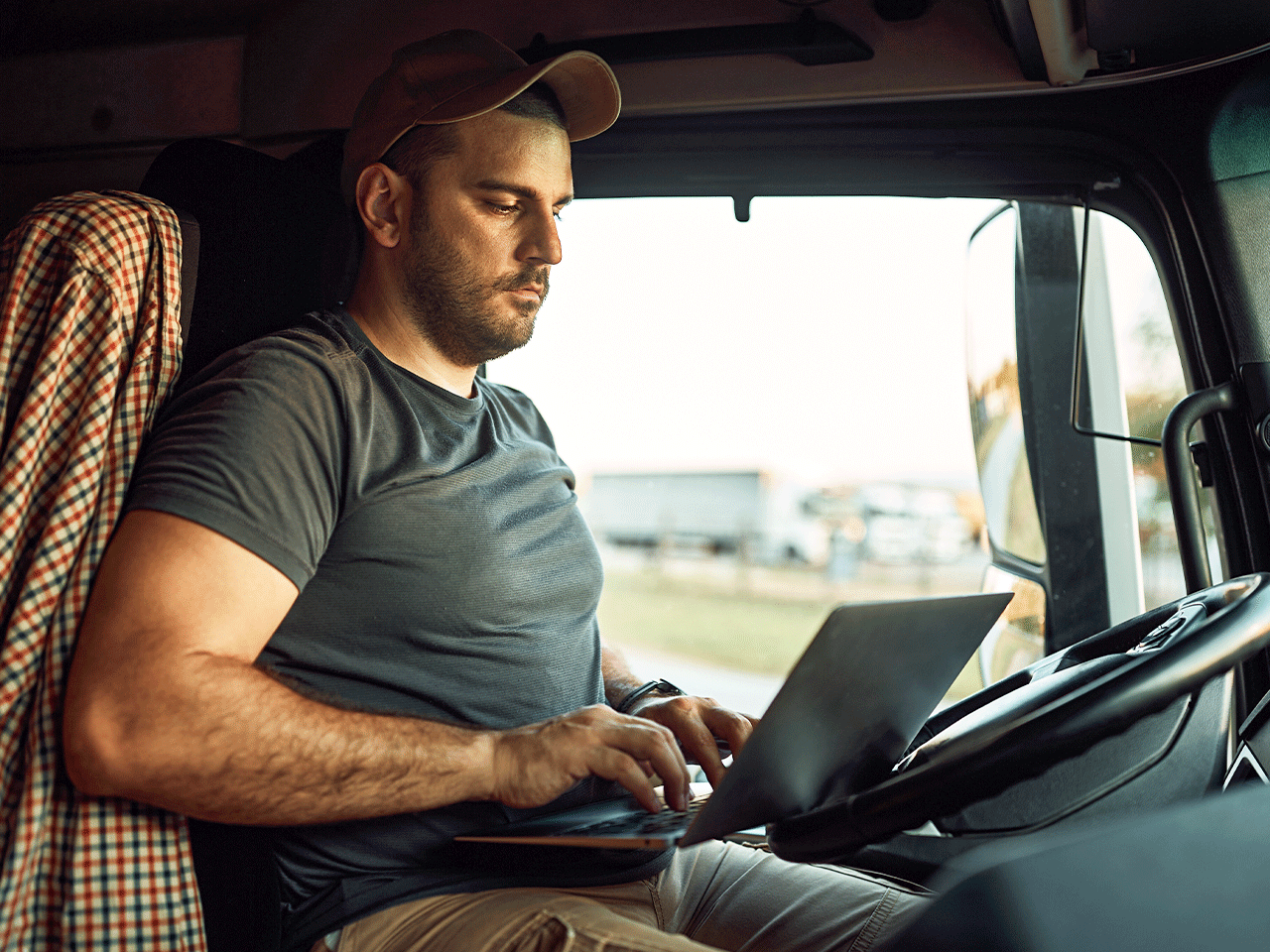 A man sitting in a truck using a laptop 
